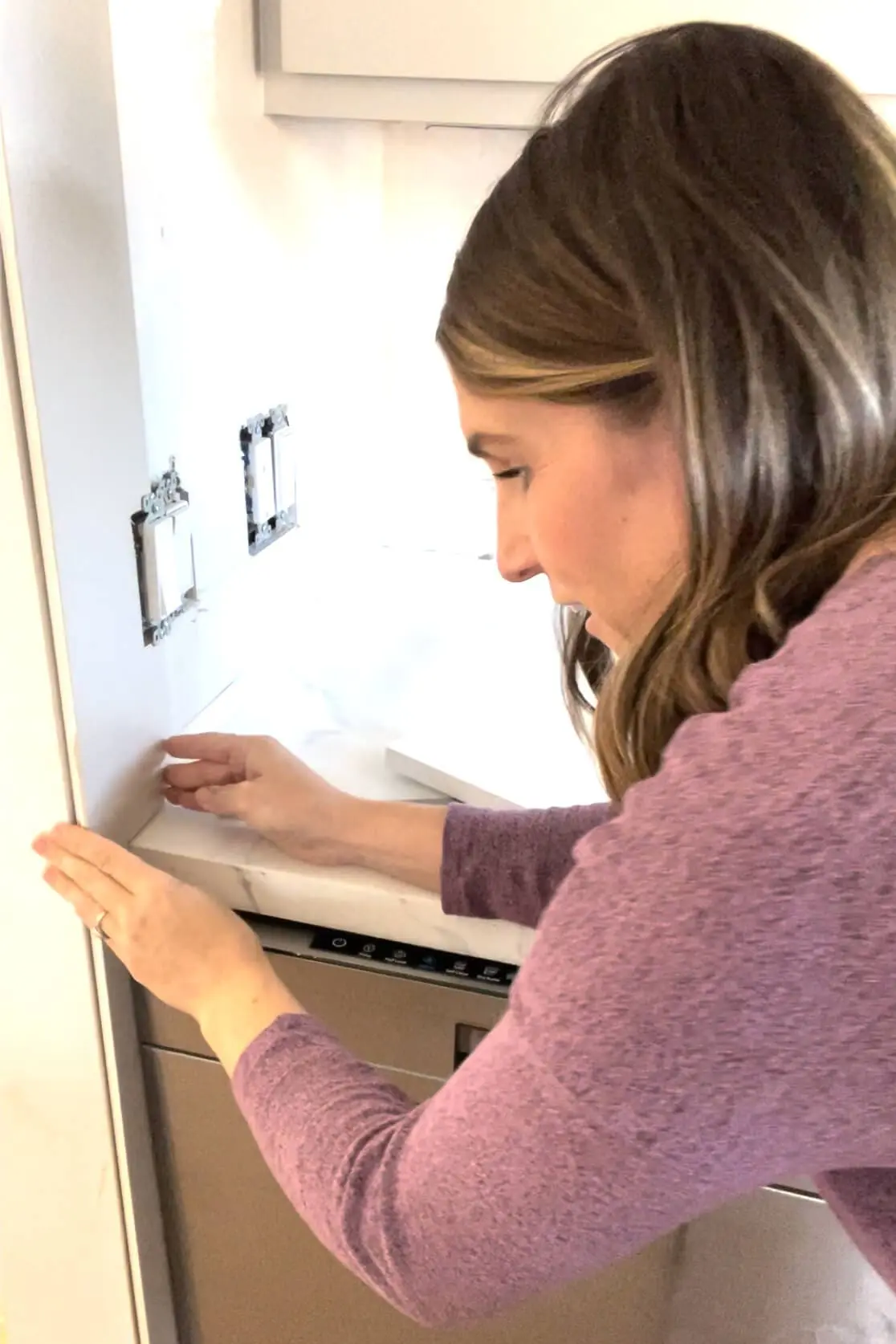 Installing a DIY shiplap backsplash.